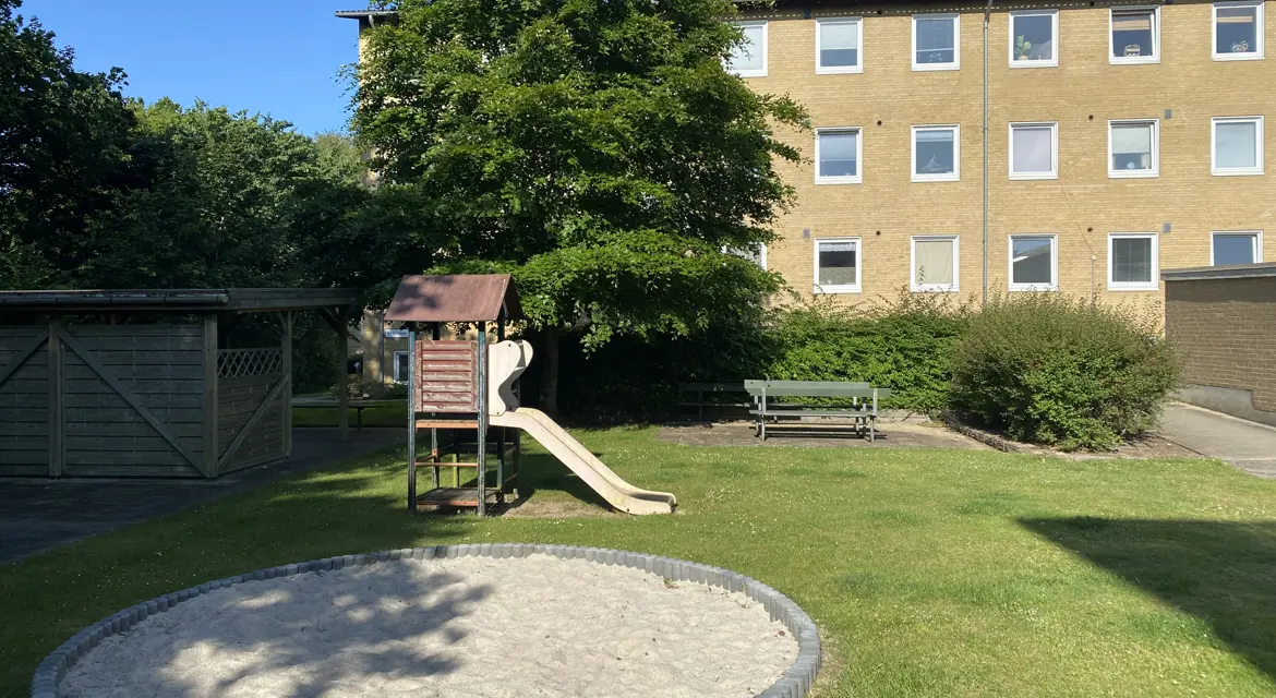Legeplads med sandkasse og rutchebane