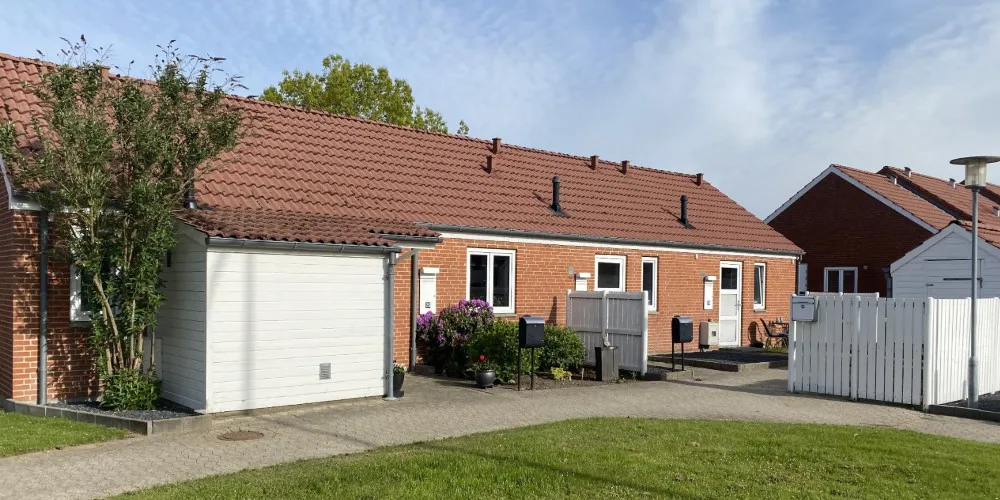 Rækkehuse i røde mursten med hyggelige forhaver