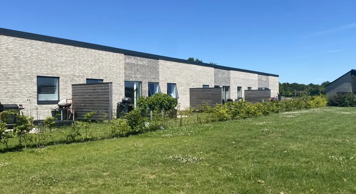 Rækkehuse i grå mursten og egen have adskilt af hegn