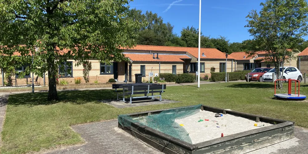 Rækkehuse opført i gule mursten med legeplads