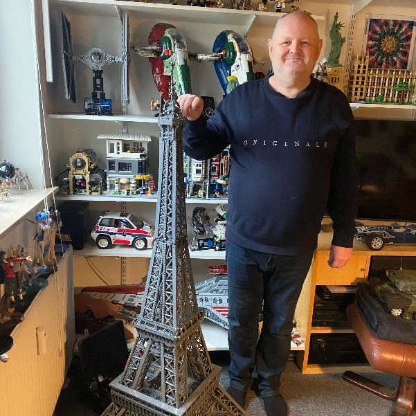 Beboeren i fokus står ved et stort Lego eiffeltårn