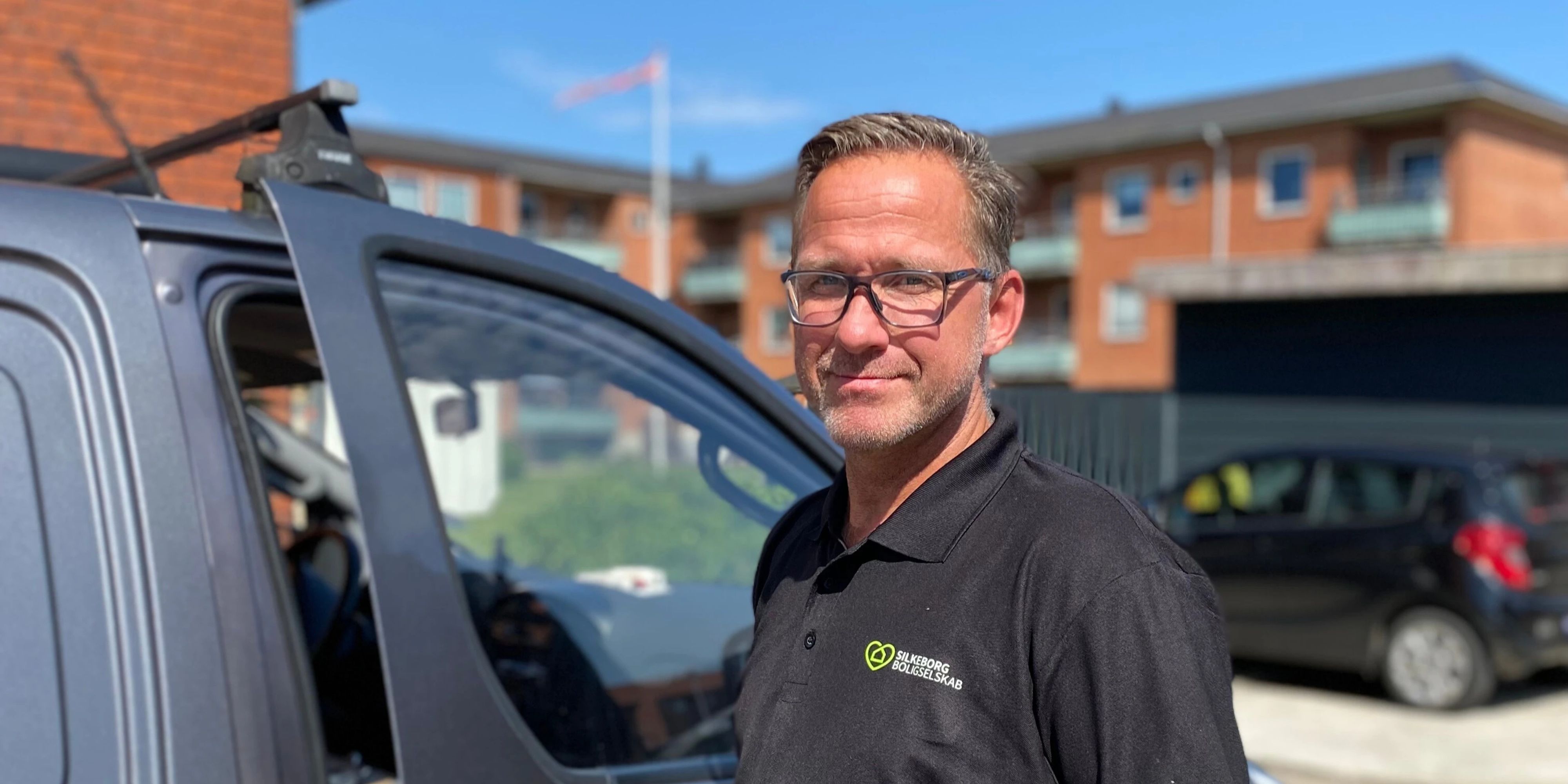 John fra driften står foran sin bil