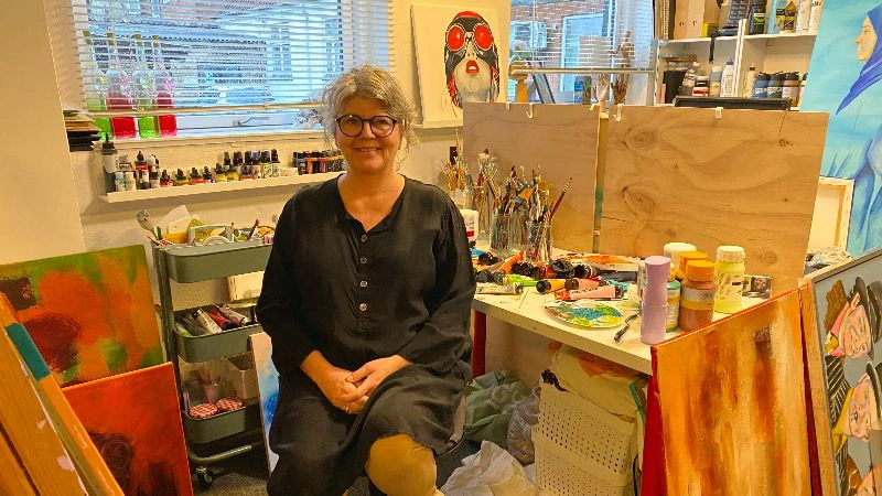 Helle sidder på en stol i sit kreative værksted