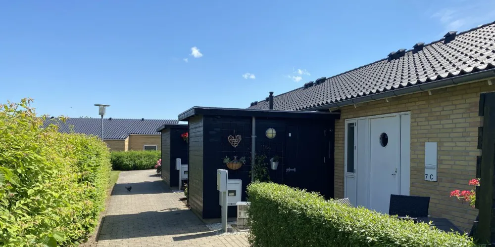 Rækkehuse i gule mursten med hyggelig forhave