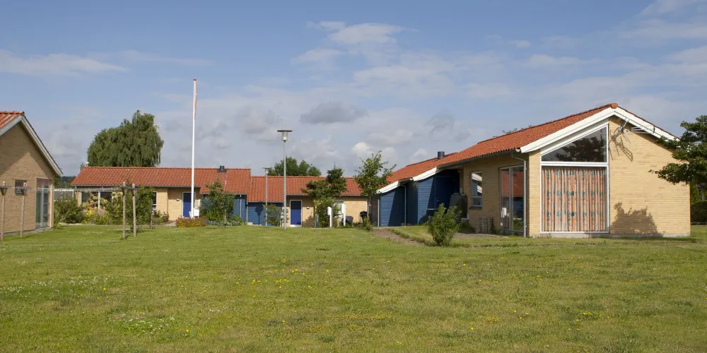 Rækkehuse i gule mursten med græsplæne