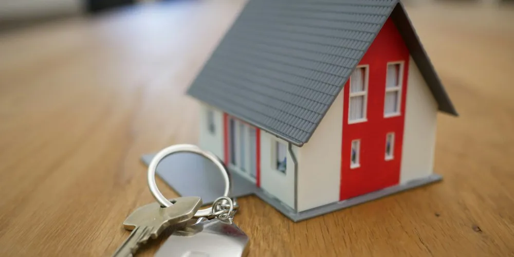 Miniature bolig med en nøgle ved siden af