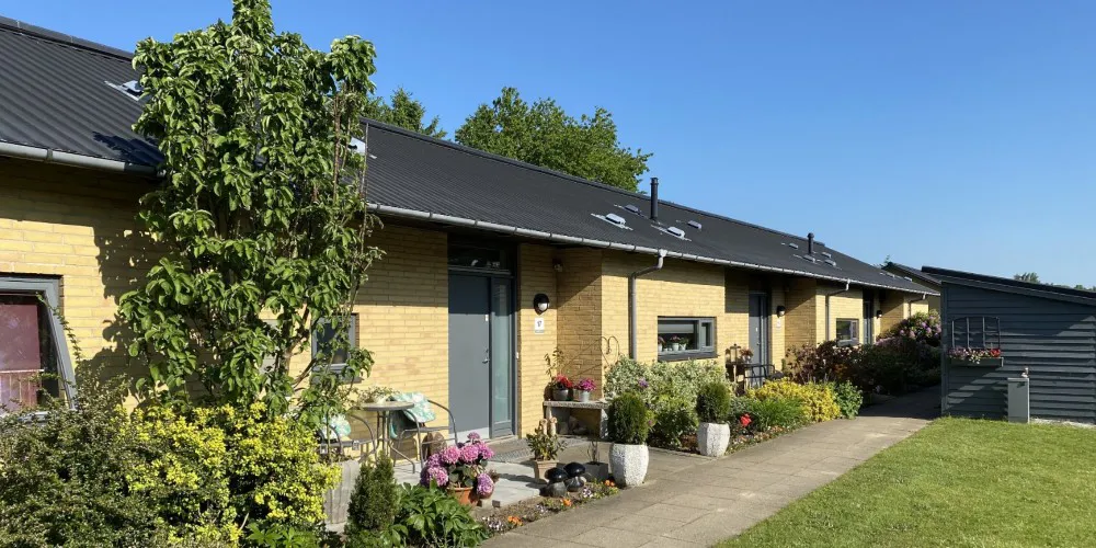 Rækkehuse i  gule mursten med hyggelige forhaver