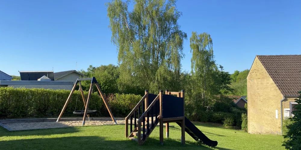 Rækkehuse i gule mursten med legeplads