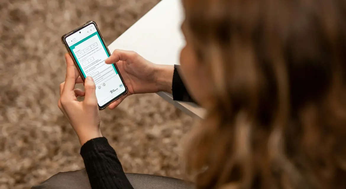 Kvinde der besvarer et spørgeskema på sin mobiltelefon