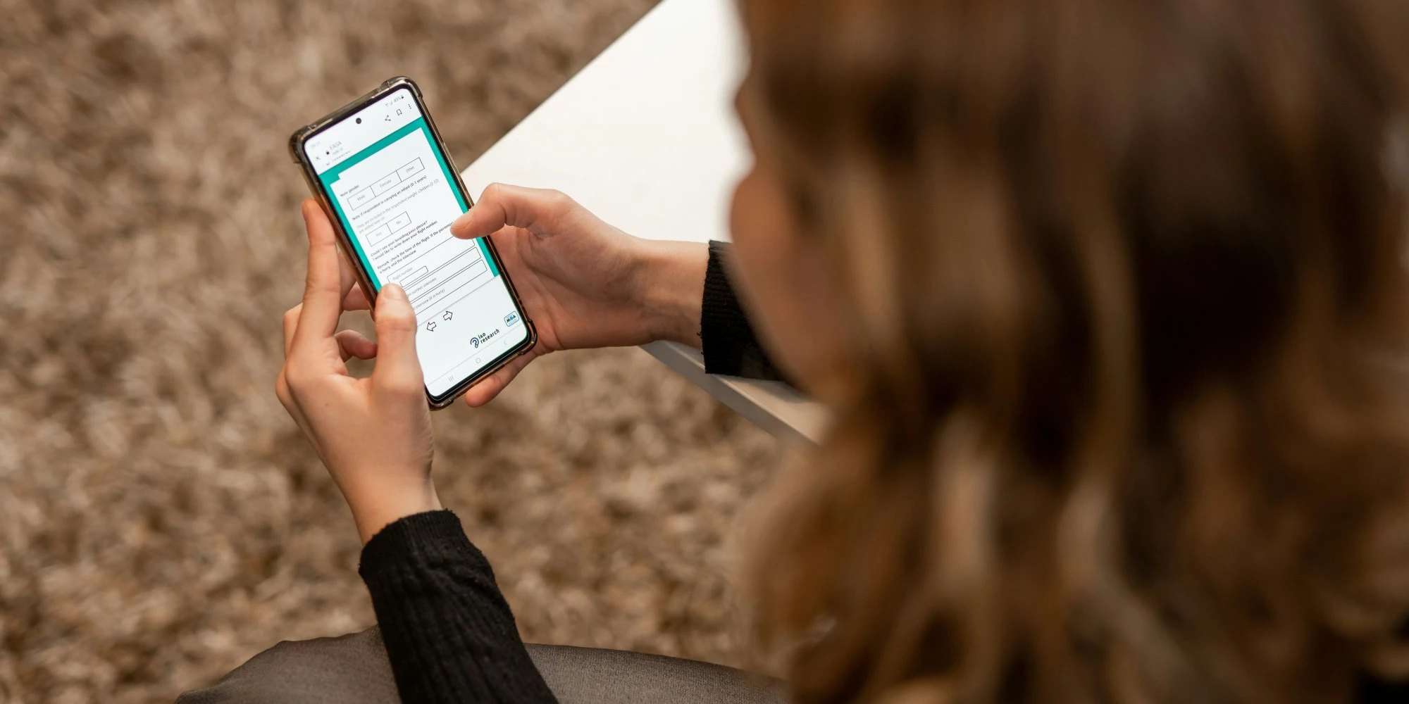 Kvinde der besvarer et spørgeskema på sin mobiltelefon